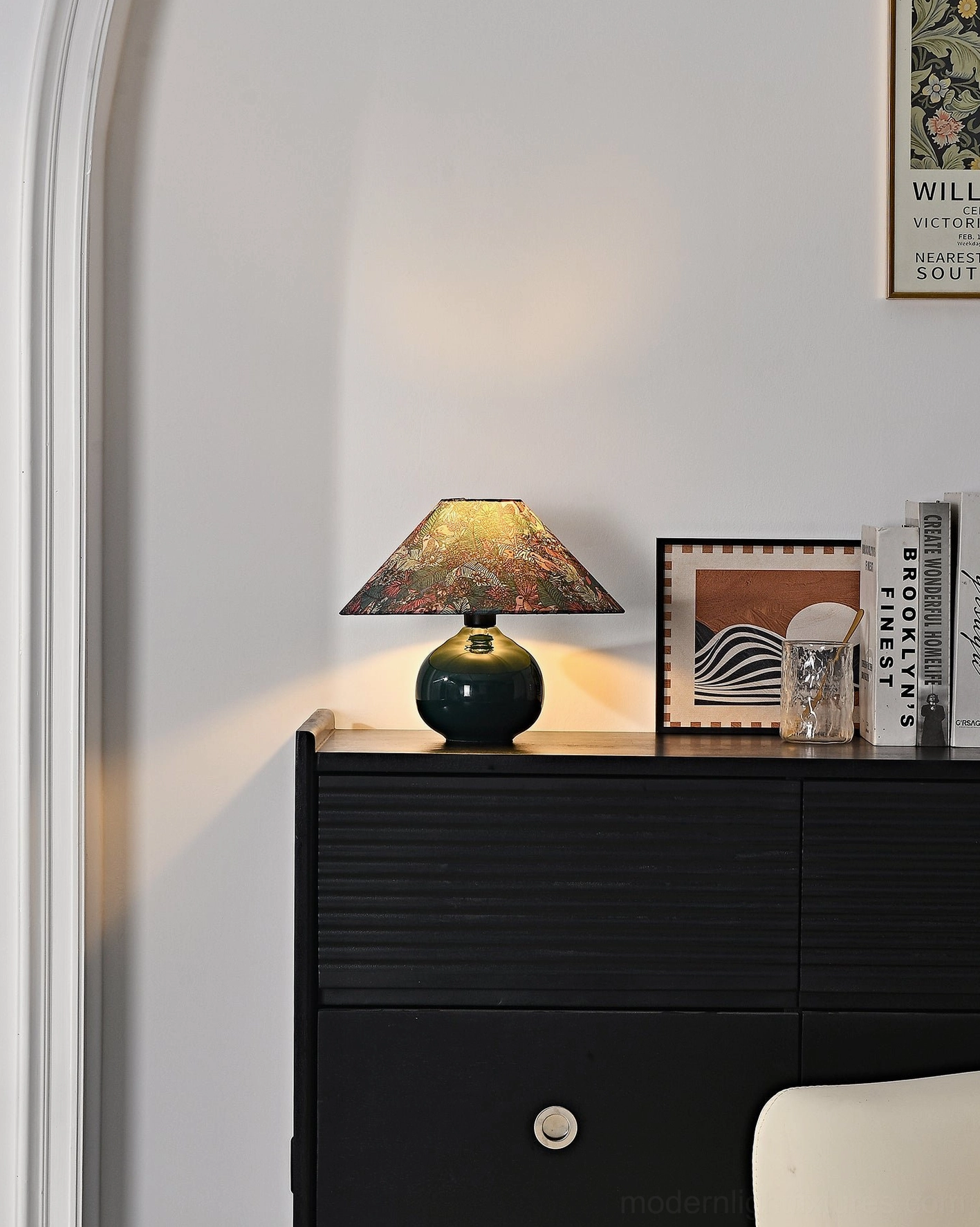 Forest green botanical table lamp on entryway console table creating soft bedside lighting effect in modern home setting