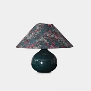 Botanical ceramic table lamp with forest green glossy base and intricate botanical fabric shade featuring wildlife patterns - studio view
