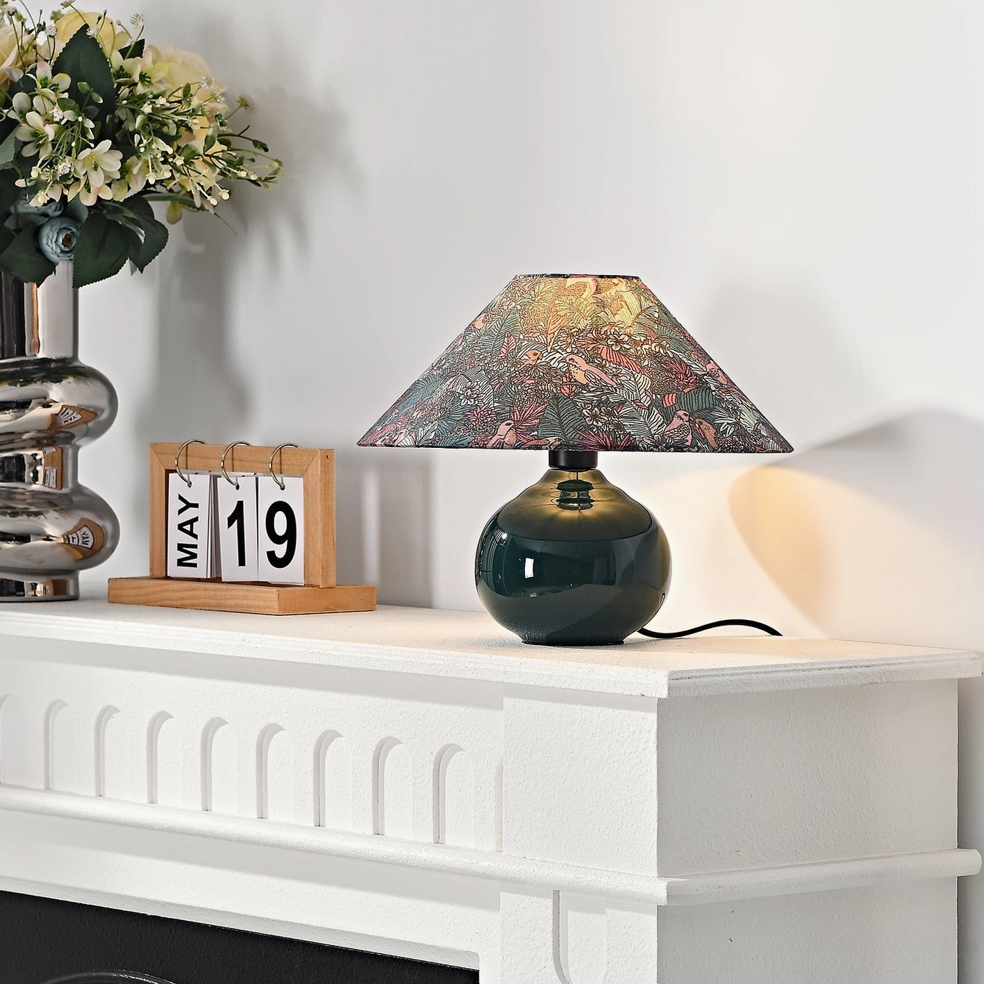 Forest green botanical table lamp demonstrating soft light diffusion through patterned fabric shade for ambient home lighting