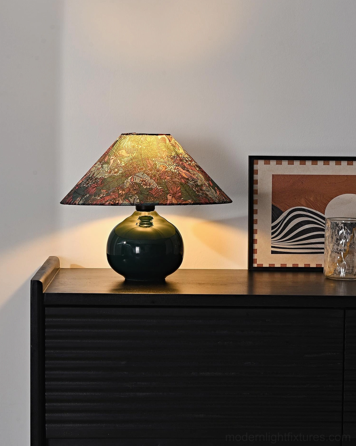 Contemporary ceramic table lamp on dark wooden dresser showing botanical shade design with warm side lighting and home decor styling