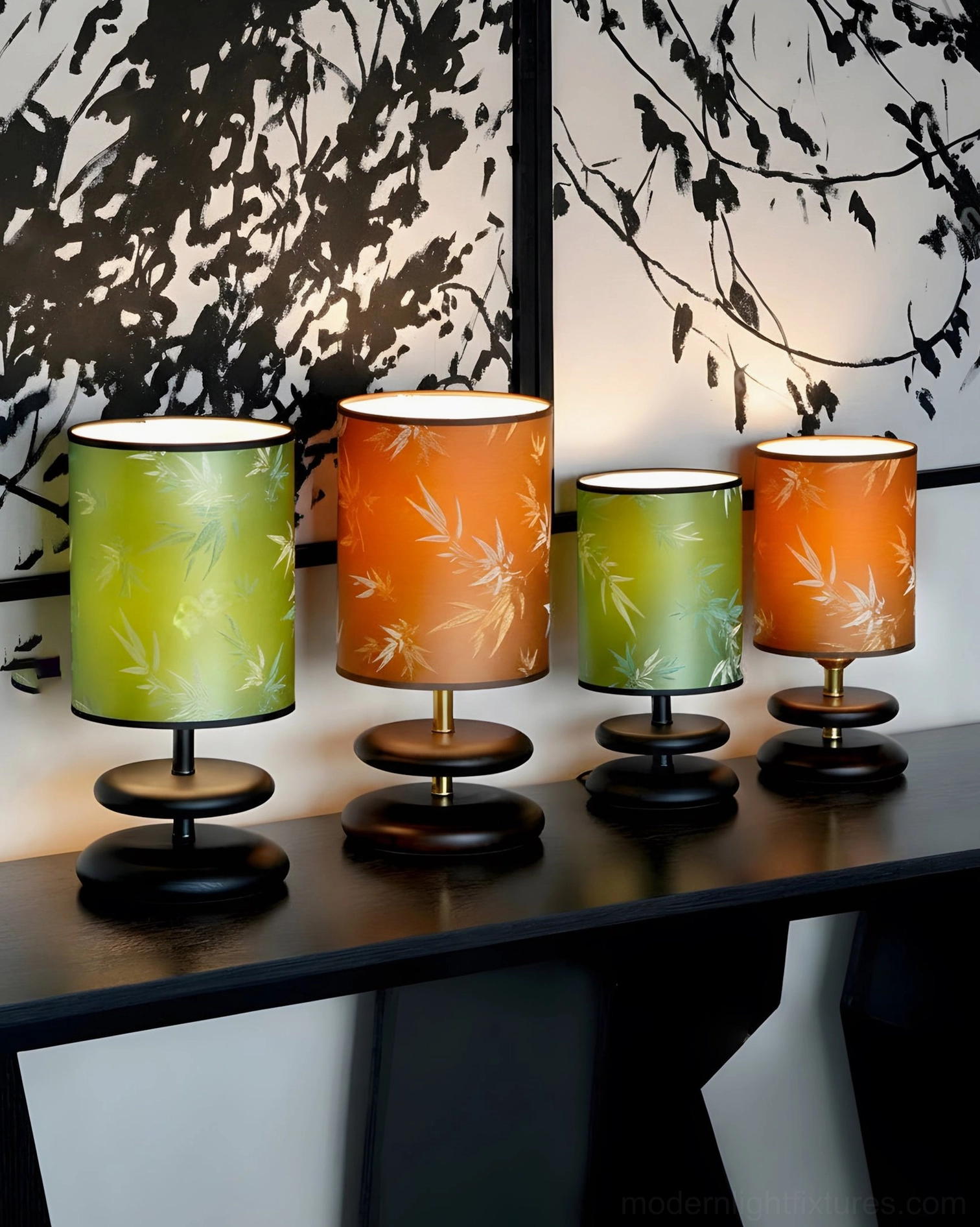 Set of four matching botanical table lamps with green and orange bamboo-pattern shades and uniform dark bases with gold details