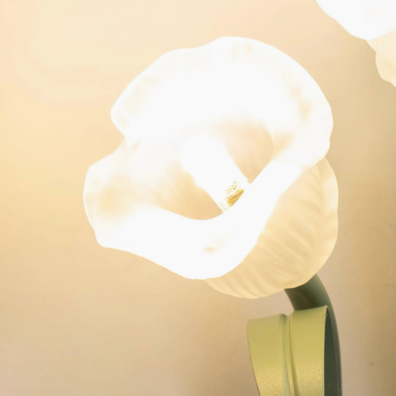 Green wall sconce botanical design detail, white flower accents modern floral light fixture close-up