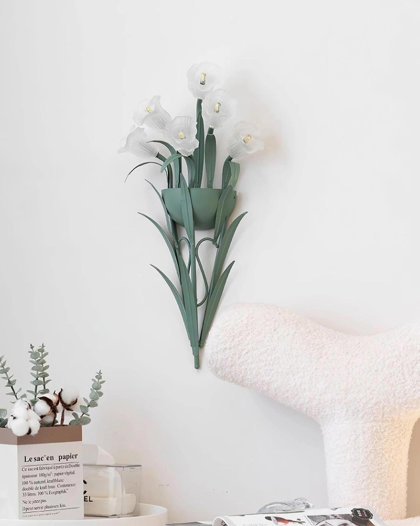 Green botanical wall sconce in Nordic bedroom setting with side table and chair, decorative floral wall light