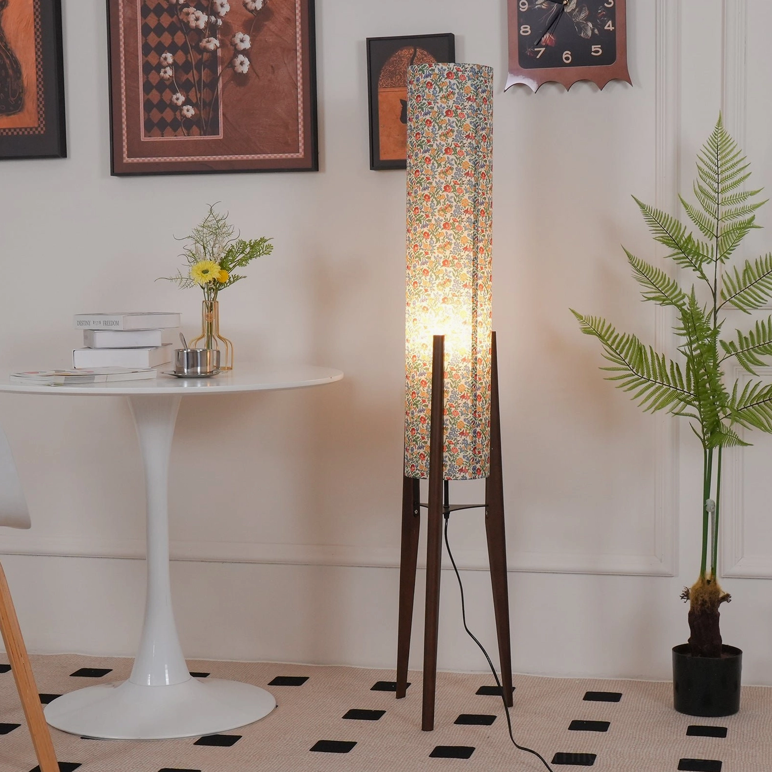 Wooden tripod floor lamp with botanical floral fabric shade creating warm ambient lighting in interior space
