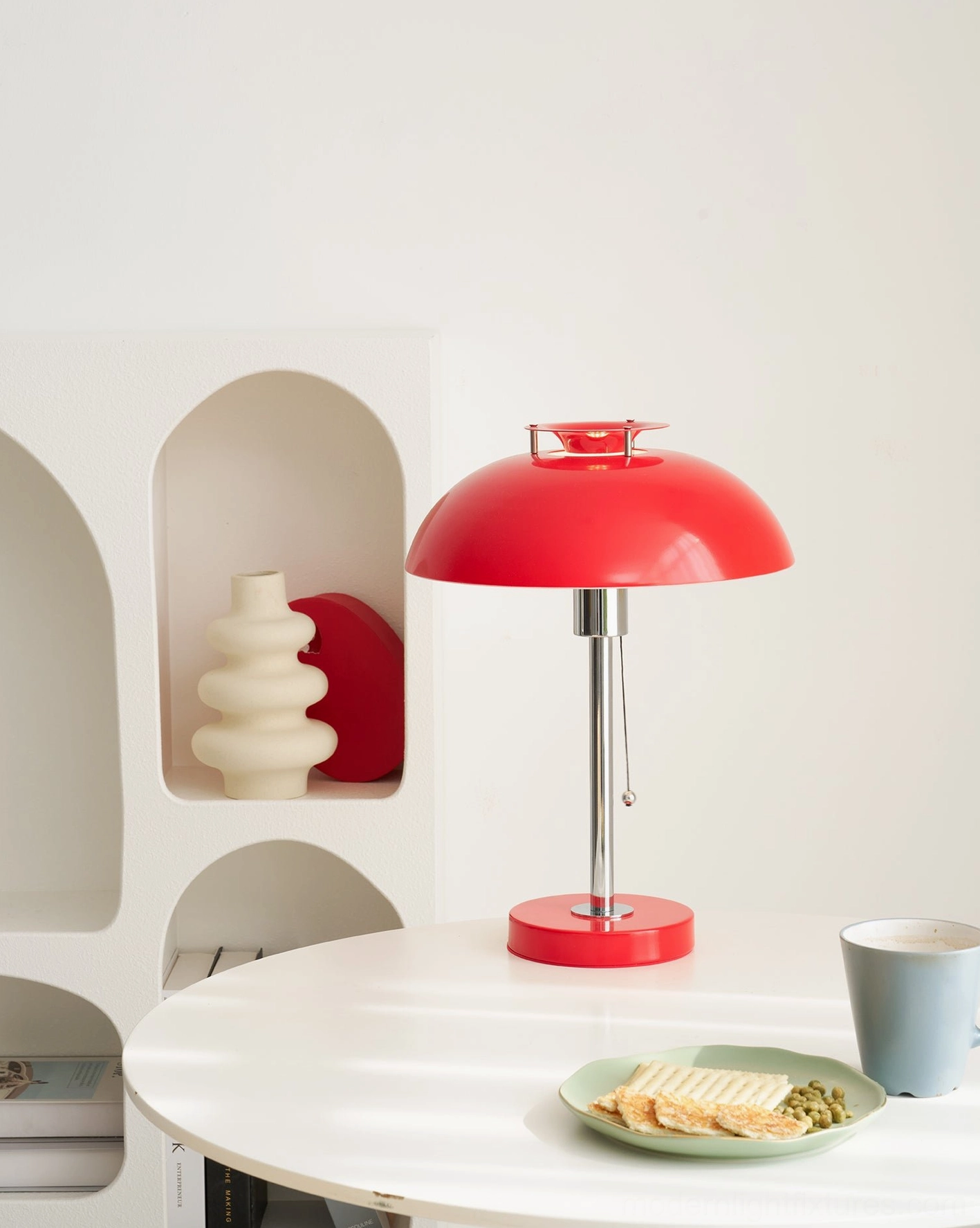 Red Bowie table lamp on white dining table with decorative shelf and tableware accessories