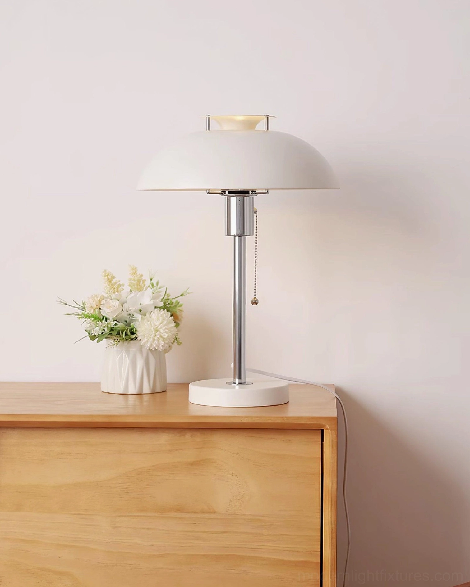 Bowie cream white table lamp three-quarter side view on wooden cabinet with polished chrome pole and matte finish