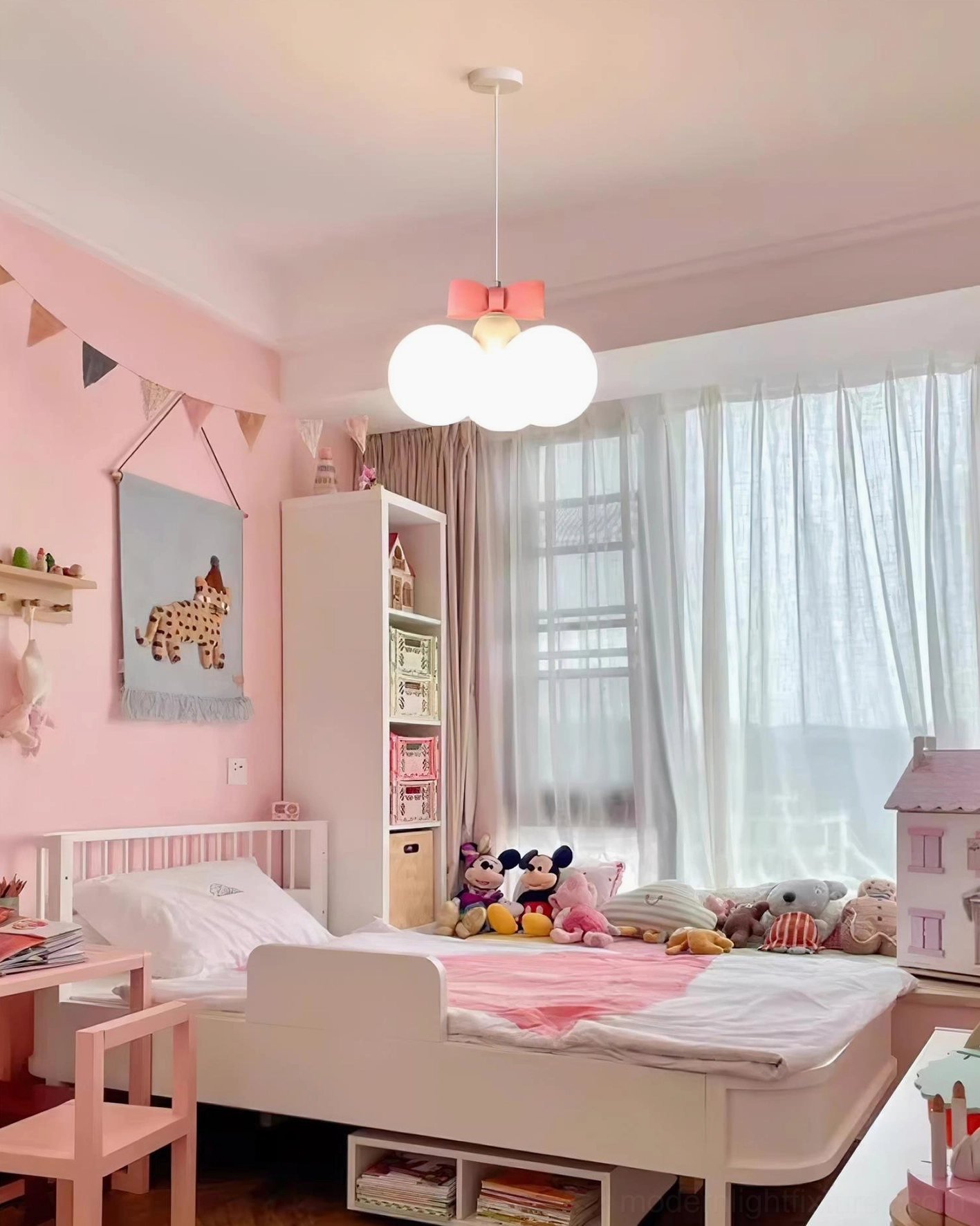 Bowknot pendant light in playful kids room with pink bedding, toys, and decorative wall bunting