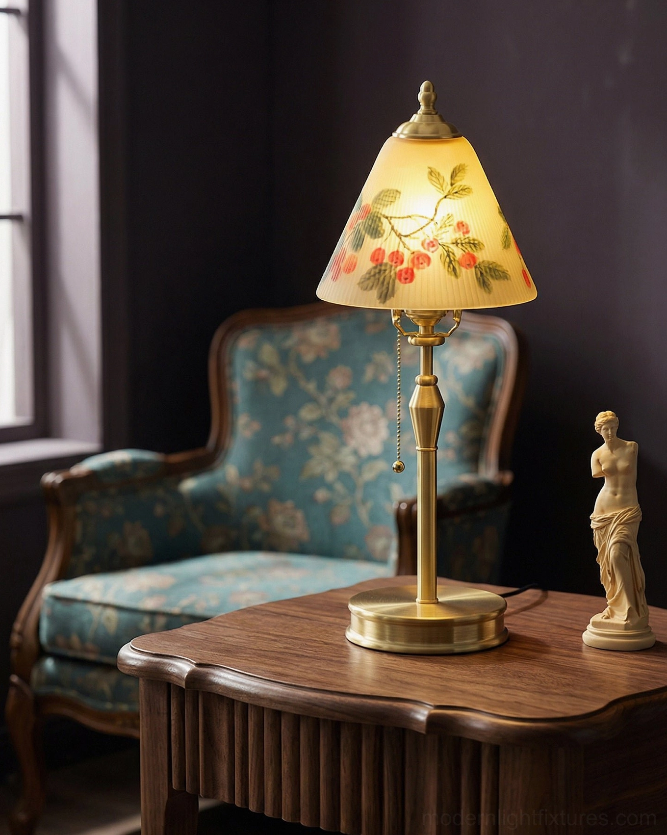 Bramelle brass table lamp glowing in vintage reading corner with floral upholstered chair and resin statue on carved wooden side table