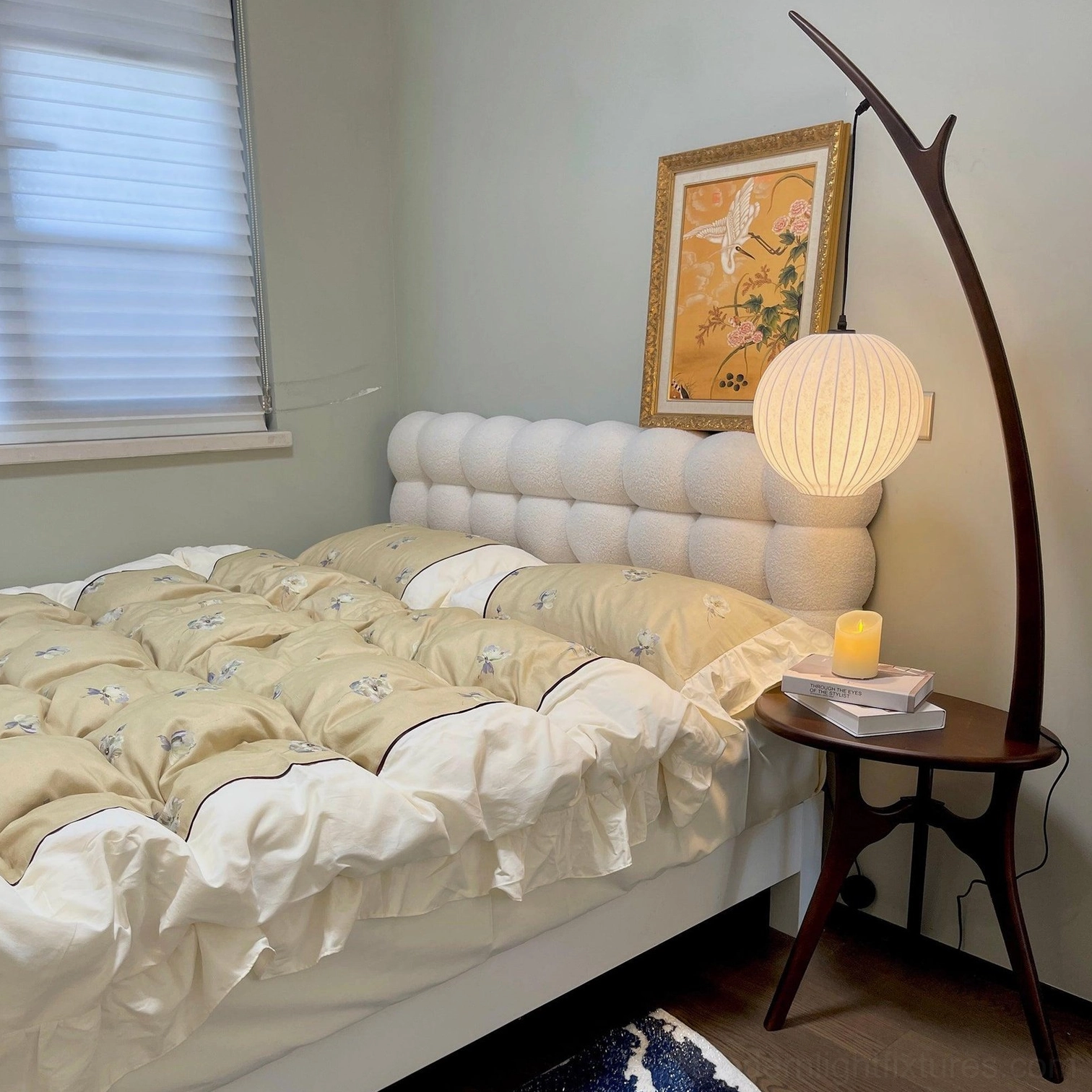 Organic branch floor lamp with side table creating cozy reading light next to bedroom furniture
