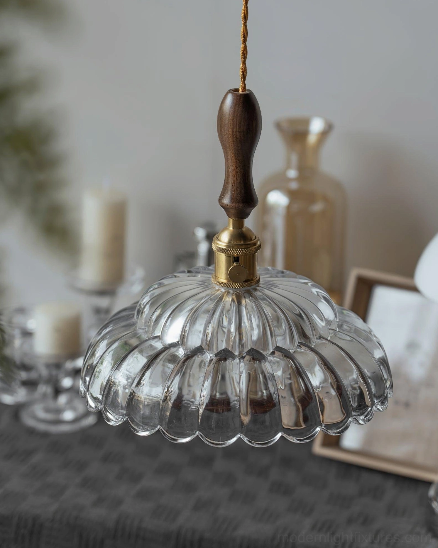 Brass fixture joint detail on walnut wood pendant light, low angle view with fluted glass shade