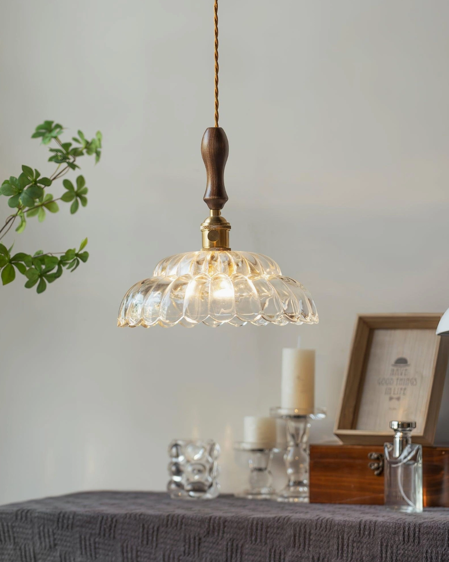 Compact pendant light with warm bulb glow, minimalist tabletop styling and clear glass shade