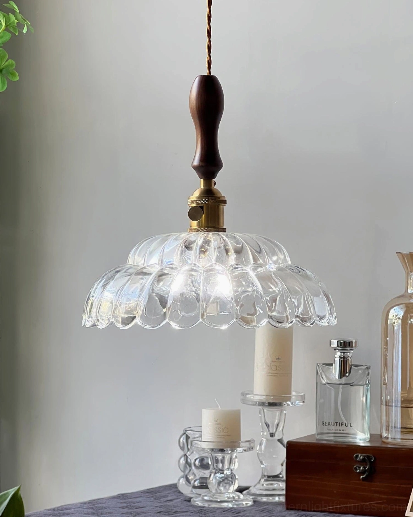 Walnut wood handle and brass-accented pendant light casting warm shadows, tabletop with glass bottles