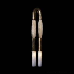 Branwick modern wall sconce illuminated against black background, showing warm ambient glow from glass diffusers and aged brass finish