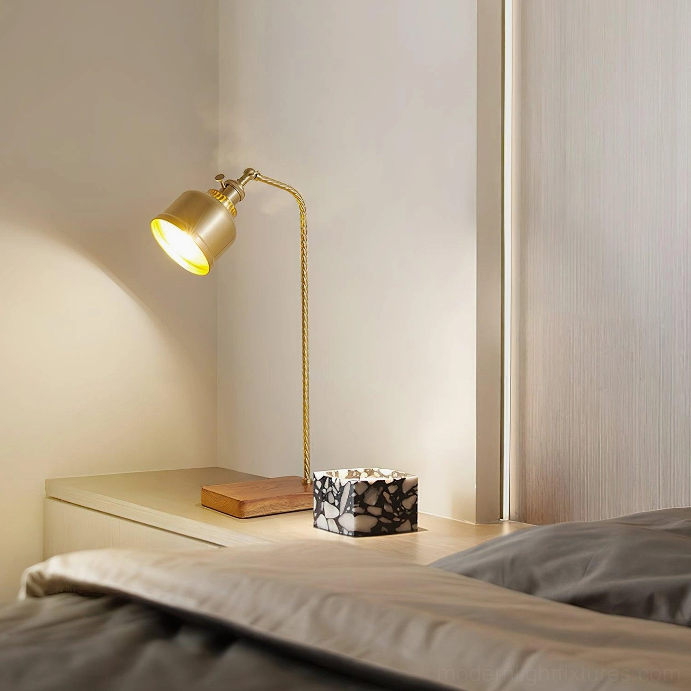 Warm brass table lamp on bedroom nightstand with decorative box, cozy ambient bedroom lighting