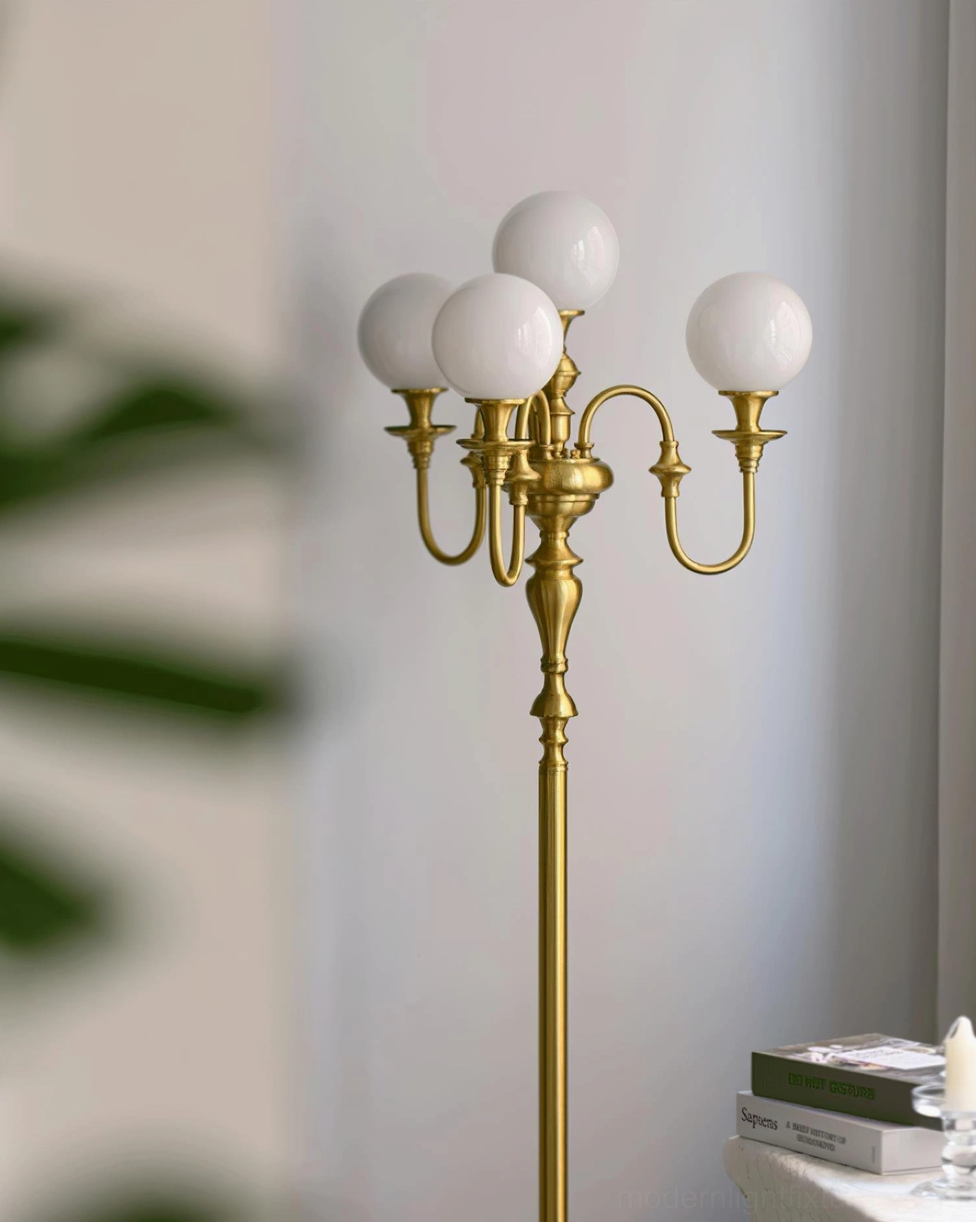 Side close-up view of brass candelabra floor lamp bedside, gold brass hardware with green leaf plant styling near bedroom table