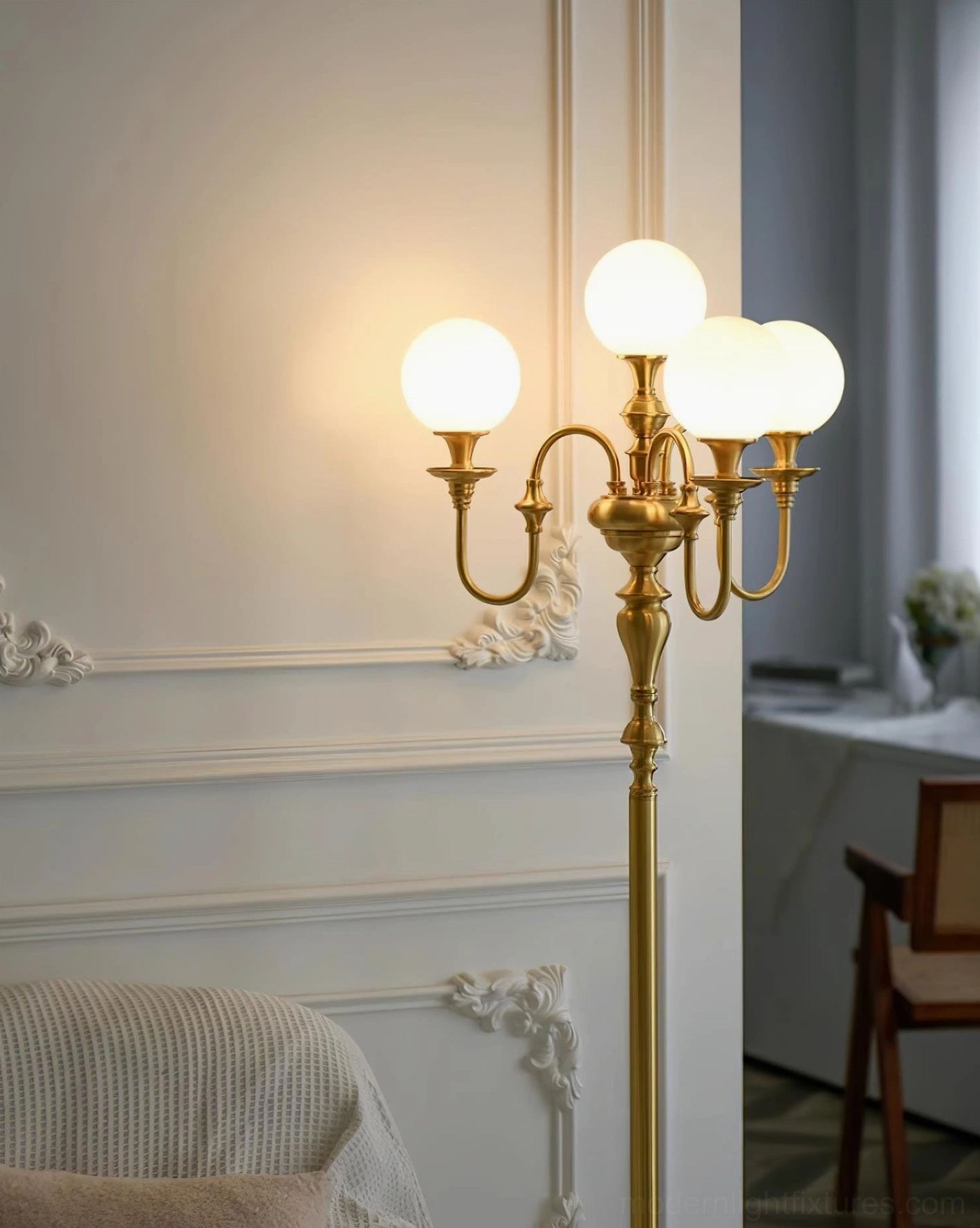 Brass candelabra floor lamp partial side view in cozy home living space with warm ambient lighting and French style wall decor