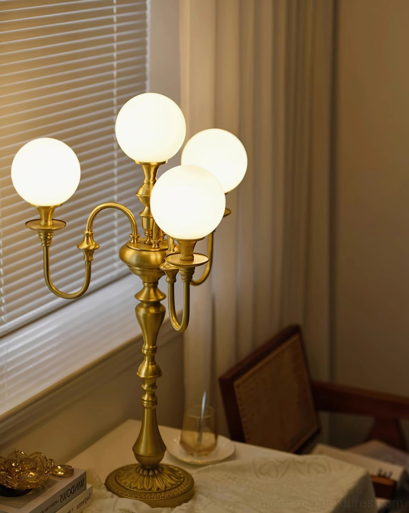 Modern brass candlestick table lamp paired with decorative objects on luxury console