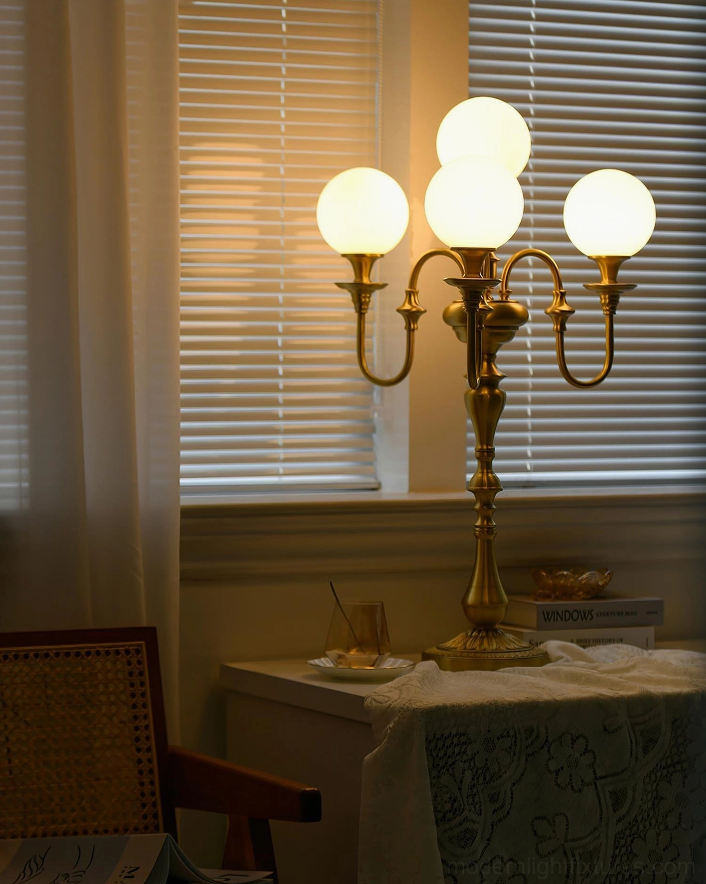 Elegant 5-head brass candlestick lamp on side table with decorative accessories and tablecloth