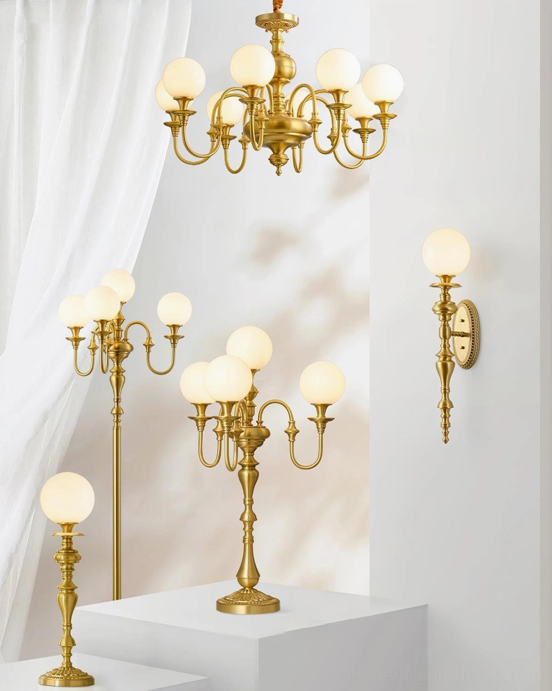 Collection of brass lighting fixtures including Beatty chandelier models with frosted glass globes, studio exhibition display