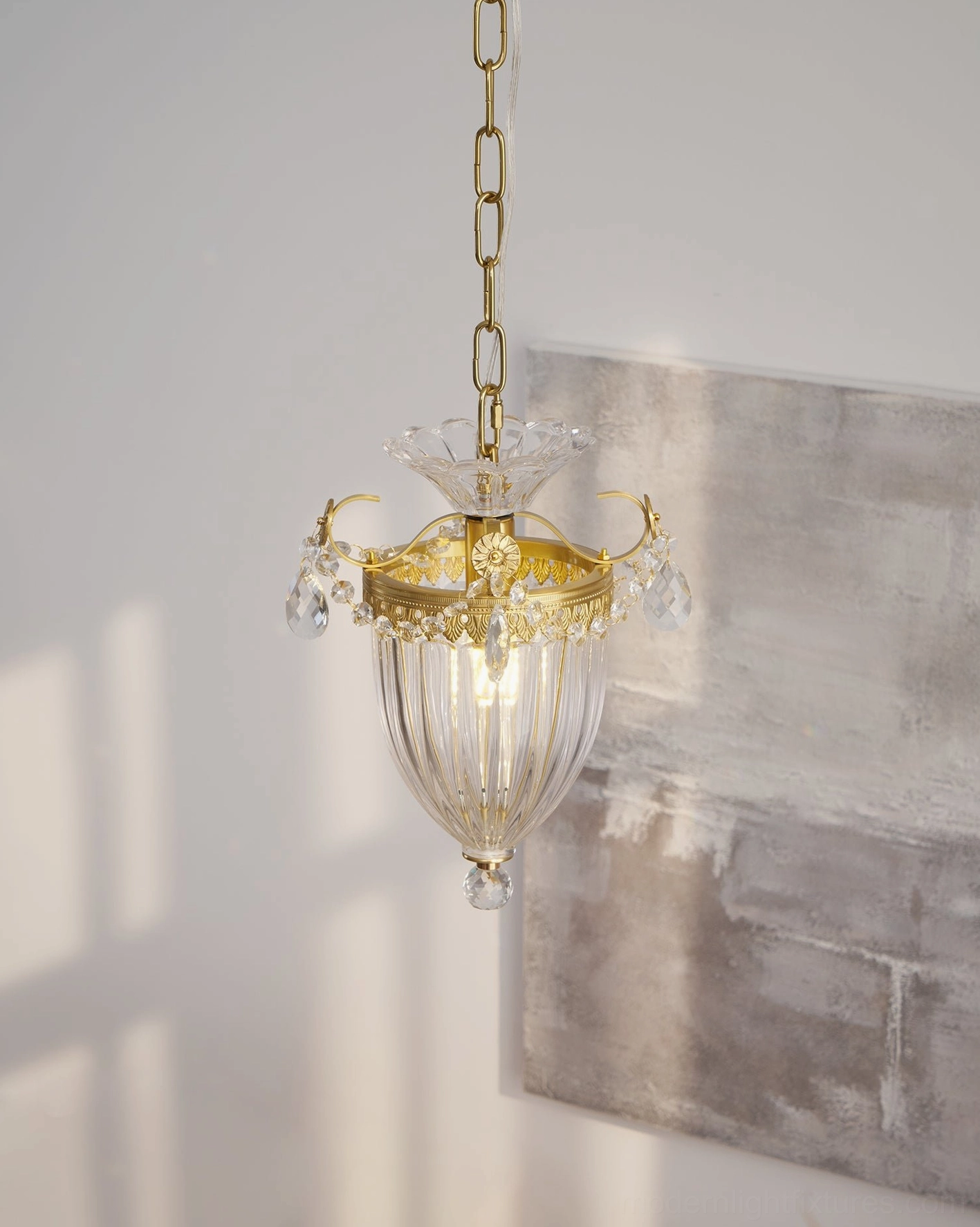 Brass crystal pendant light installed in modern dining room setting with elegant table arrangement