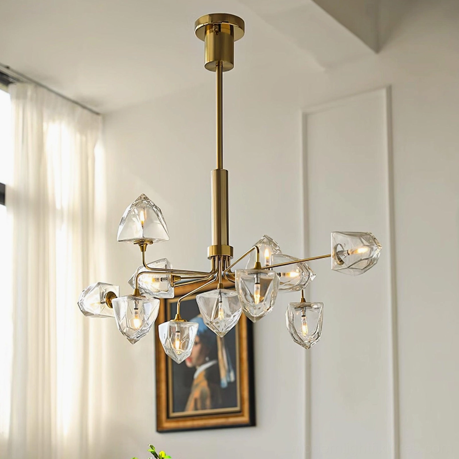 Brass gold modern chandelier with faceted clear glass shades eye-level view in residential living space