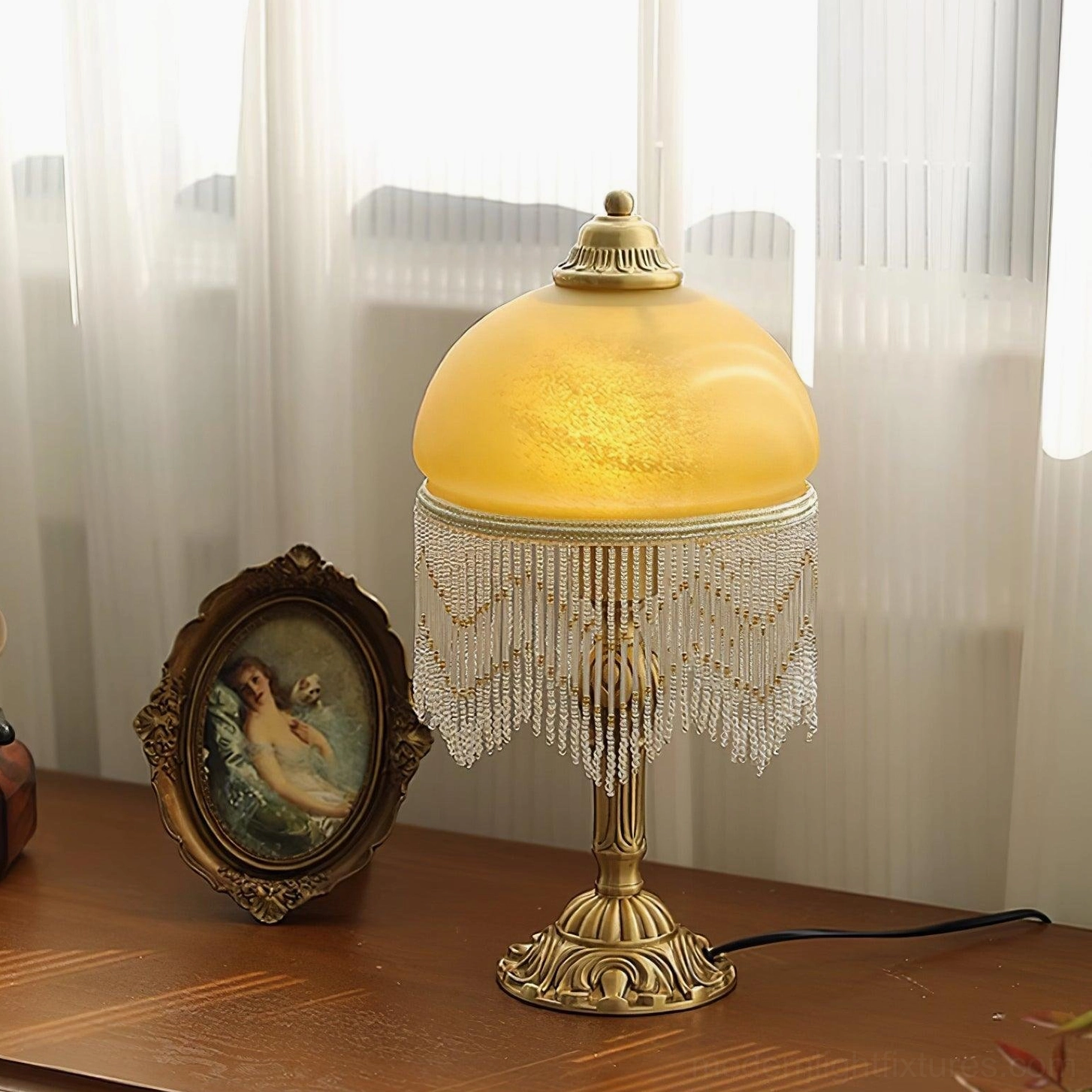 Vintage brass tassel table lamp showing beaded crystal trim detail and amber glass shade construction