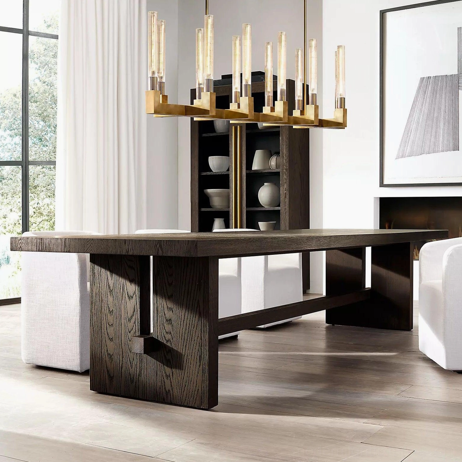Contemporary brass linear chandelier installed above luxury dining room table with warm amber lighting