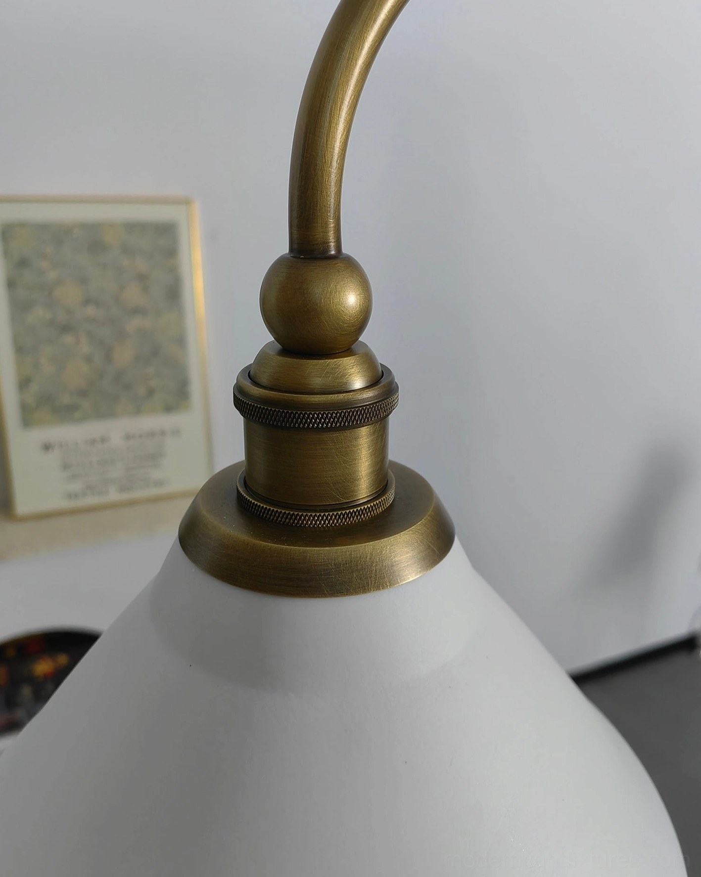 Two-light brass linear chandelier with ceramic shades providing soft diffused glow in residential interior space