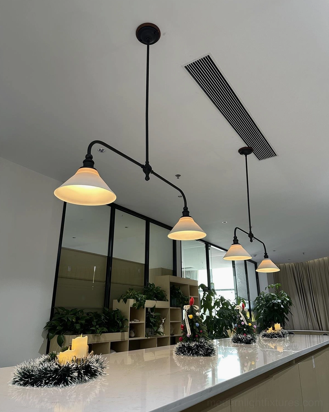 Brass frame linear pendant fixture with matching white ceramic conical shades showcasing balanced geometric design