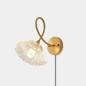 Brass lotus leaf wall sconce with twisted metal arm and fluted glass shade, front-left view showing warm illumination