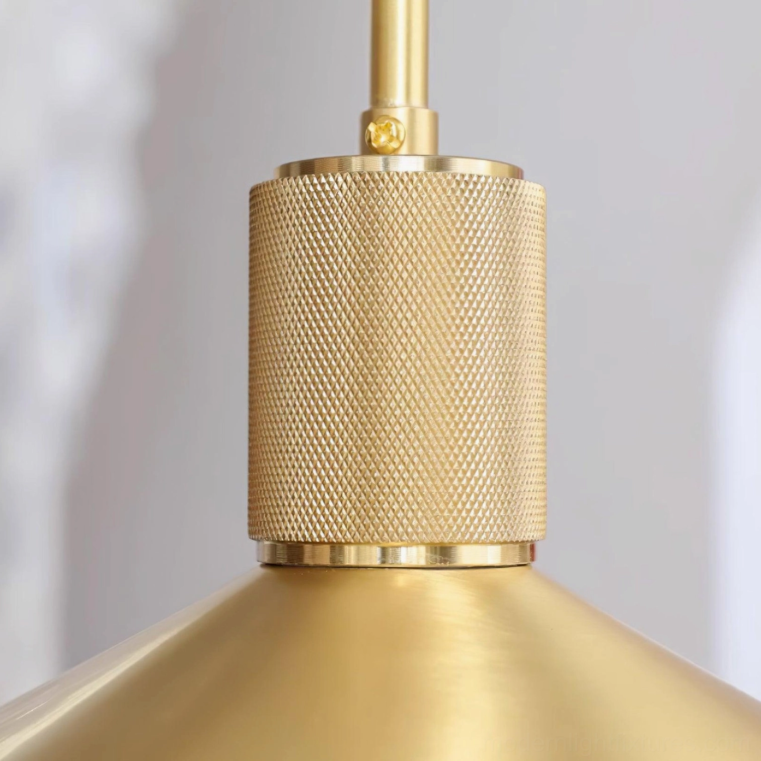 Brass pendant light fixture installed in eclectic bedroom corner creating warm task and ambient lighting