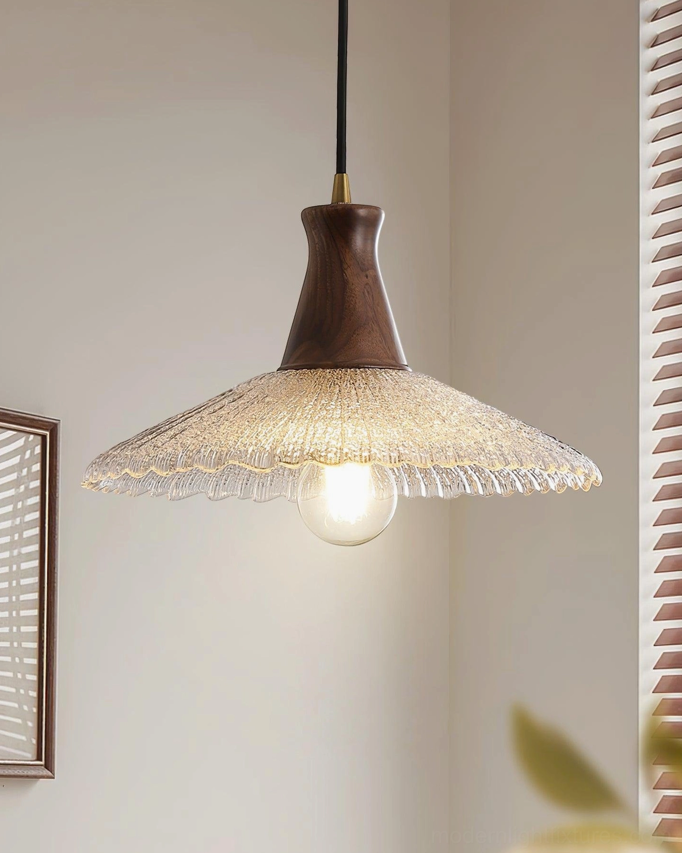 Brass connector and rippled glass pendant light fixture, side view with exposed filament illumination