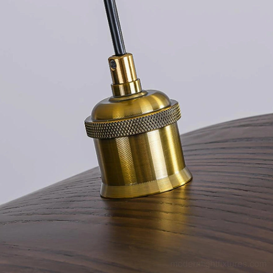 Macro close-up of walnut leaf pendant lamp's brass socket and knurled decorative detail on dark wooden tabletop