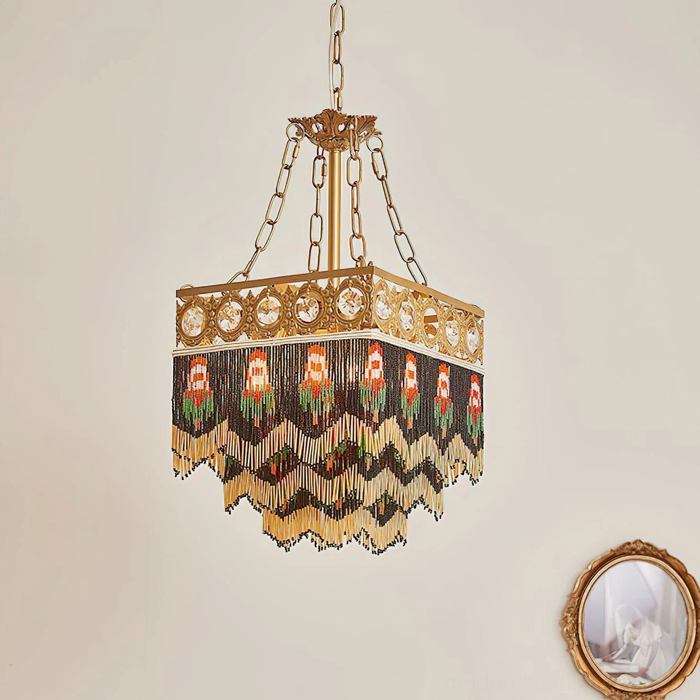 Brass square pendant lamp with handwoven beaded fringe and character motifs against decorative wall mirror