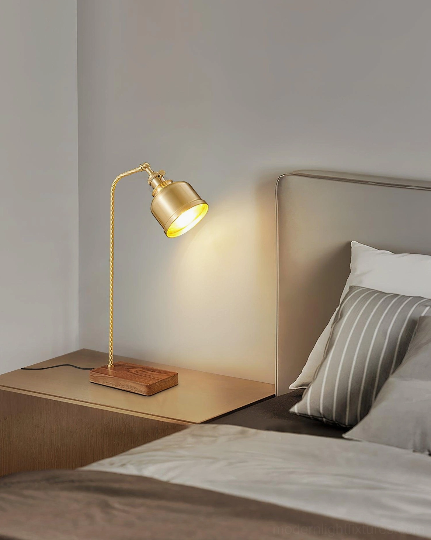 Brass table lamp illuminated showing warm light diffusion through cylindrical metal shade