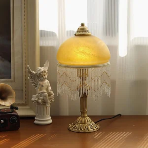 Vintage brass table lamp with amber glass shade displayed on wooden desk with European retro home decor and warm glowing light