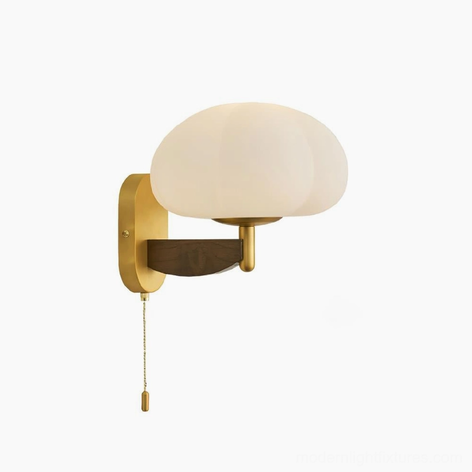 Brass-finished mid-century modern wall lamp with frosted white opal glass shade studio shot