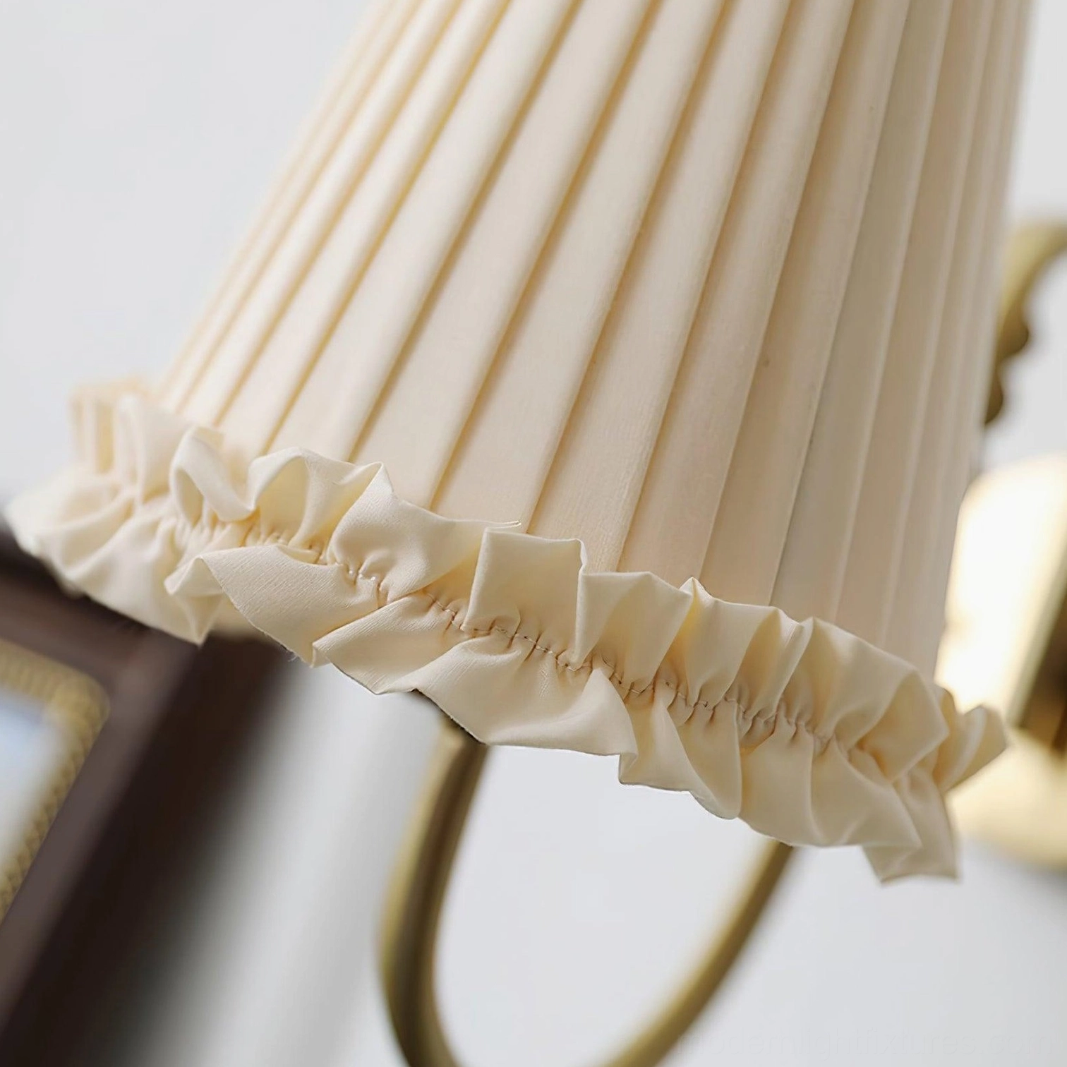 Brass wall sconce with beige pleated shade bedroom reading nook lighting