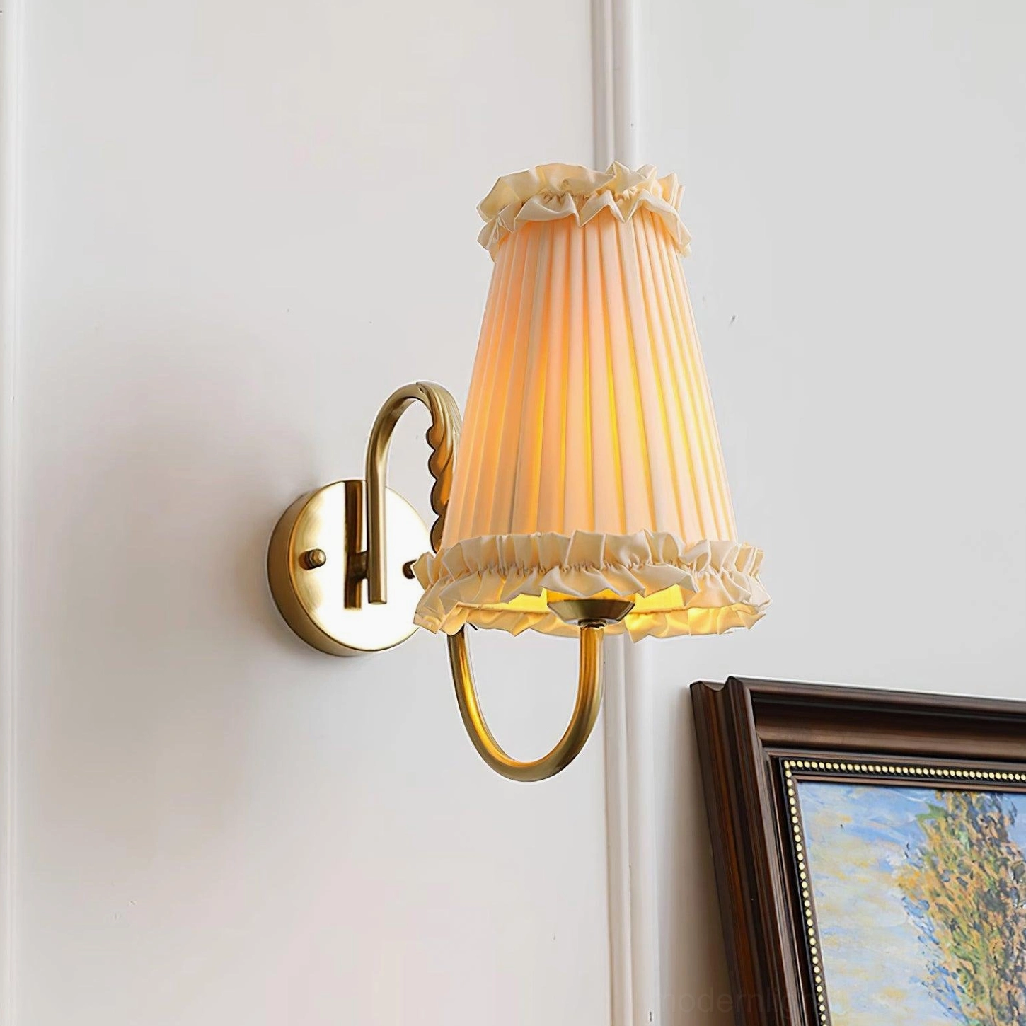 Brass wall sconce with pleated beige shade in botanical home interior styling