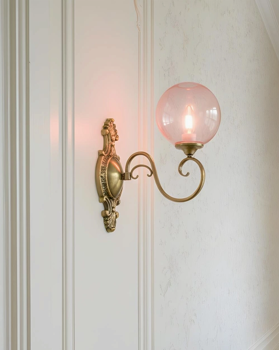 Ornate brass wall sconce with clear glass globe, vintage baroque ornate arm and backplate