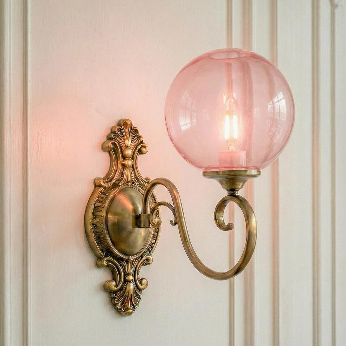 Ornate brass wall sconce with pink glass globe, single-head vintage lamp curved metal arm