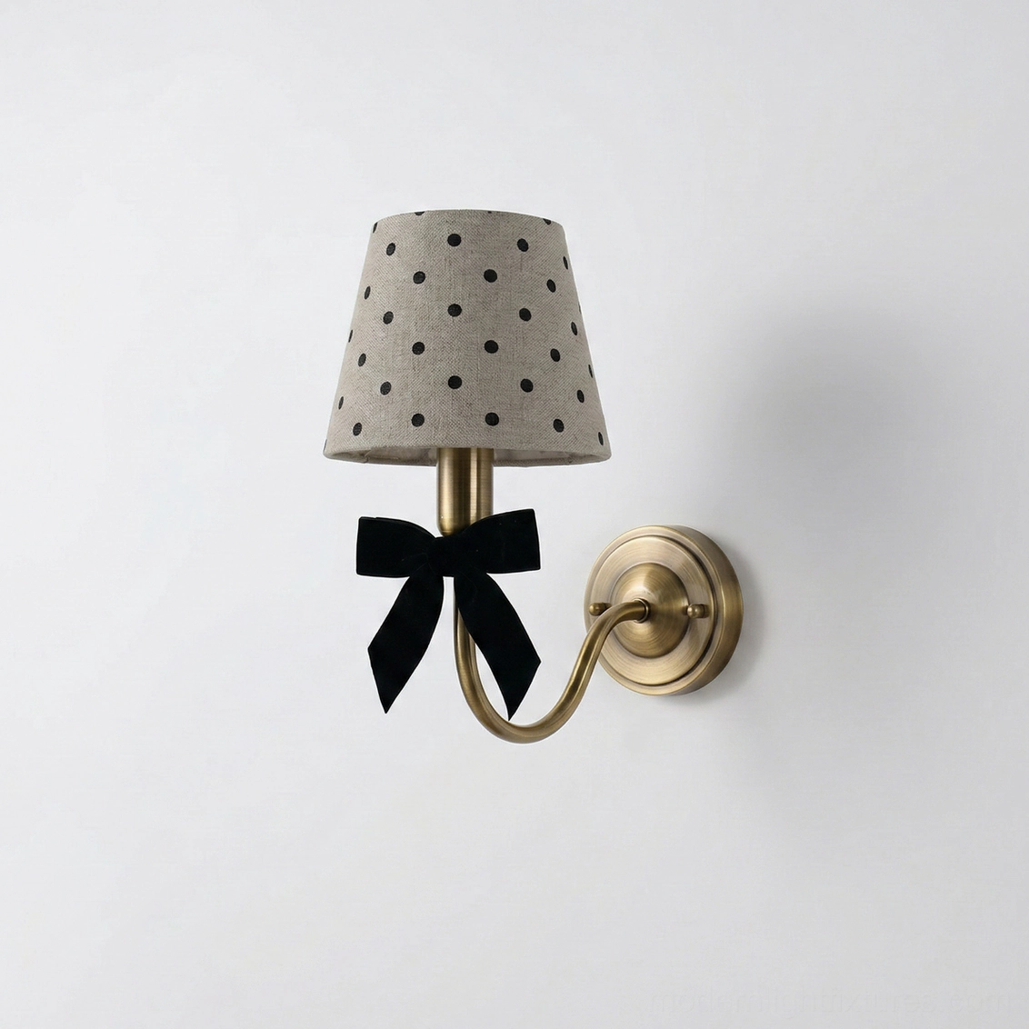 Vintage polka dot wall lamp with elegant black ribbon bow detail, brass curved arm fixture, direct frontal view on white background