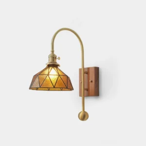 Vintage brass wall sconce with geometric amber stained glass shade and walnut base, front studio view