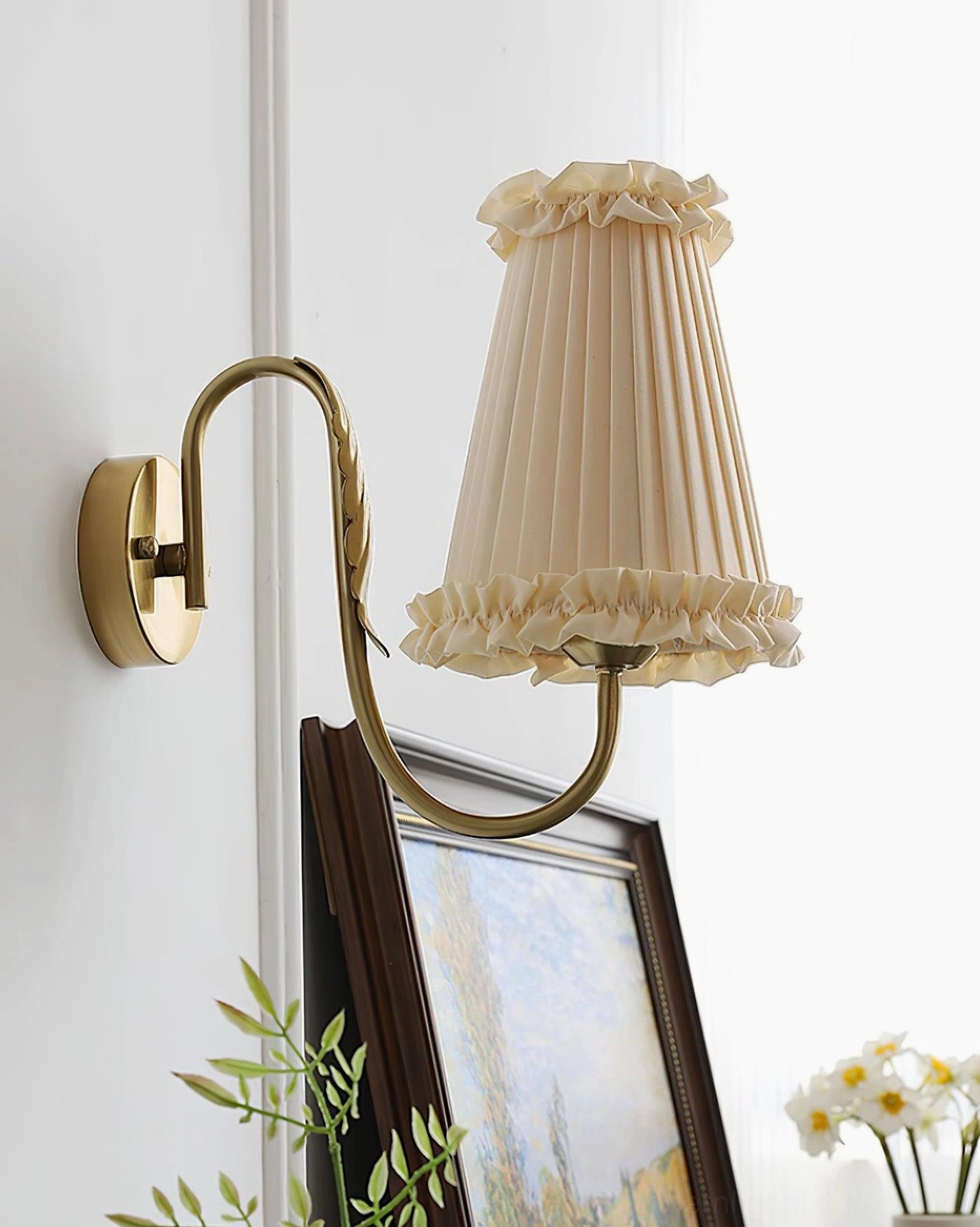 Unlit brass wall sconce with beige pleated shade side view home decor