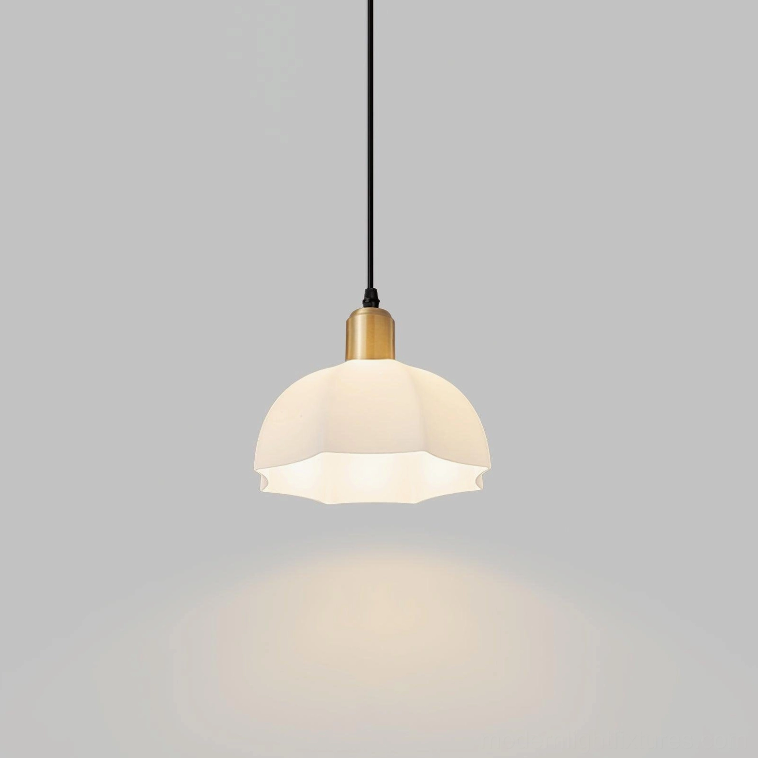 Close-up frontal view of brass and white horn scalloped pendant fixture with downlight