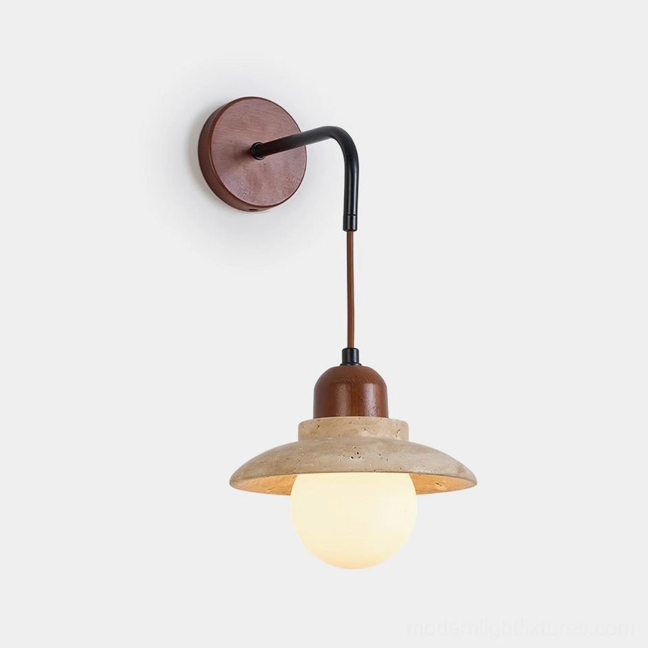 Brava travertine wall sconce front view showing dome-shaped natural stone shade with matte black metal frame