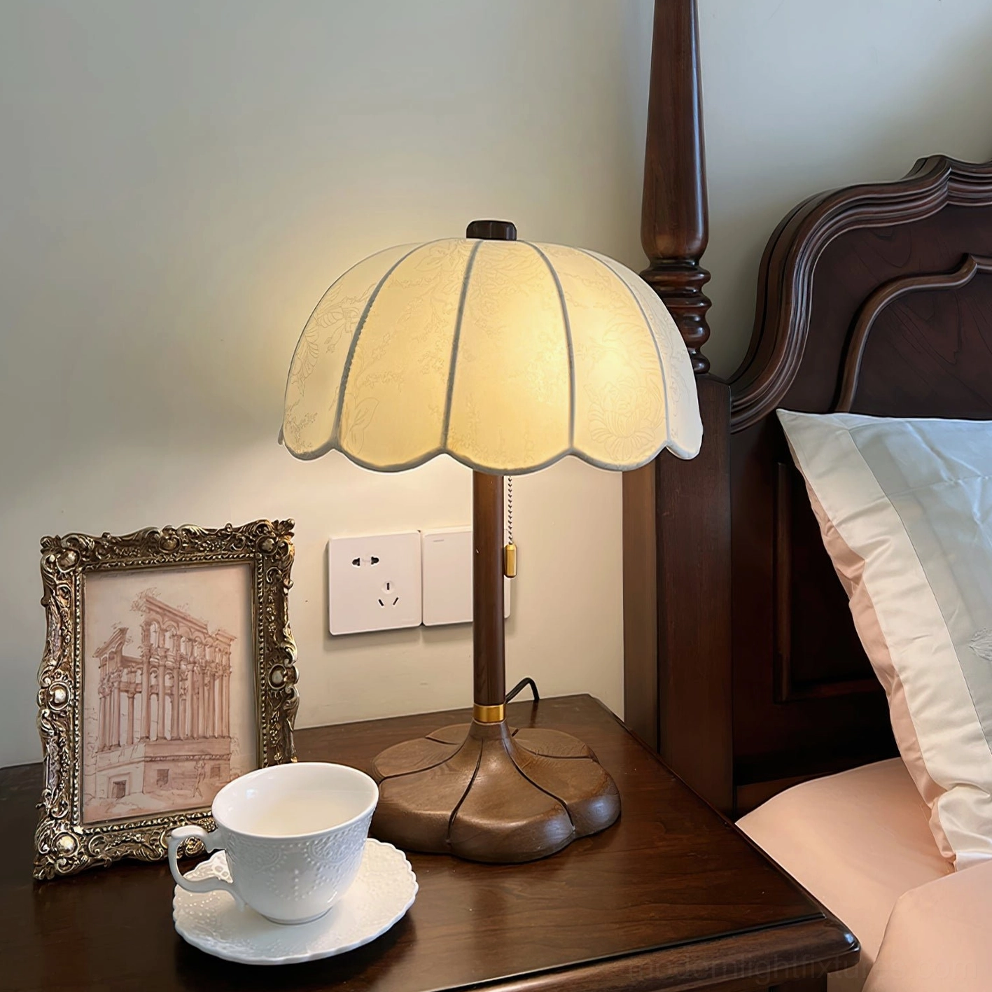 Brazoria bedside table lamp with fabric shade on walnut nightstand in traditional bedroom interior