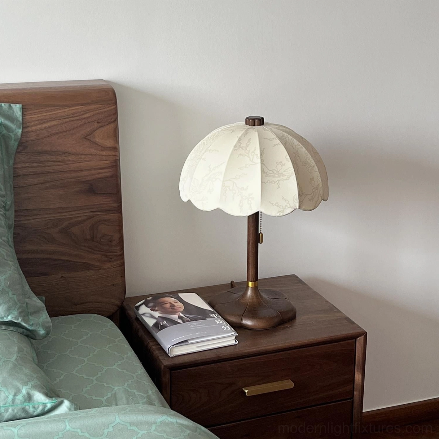 Close-up detail of Brazoria scalloped table lamp shade and wooden base on bedroom nightstand