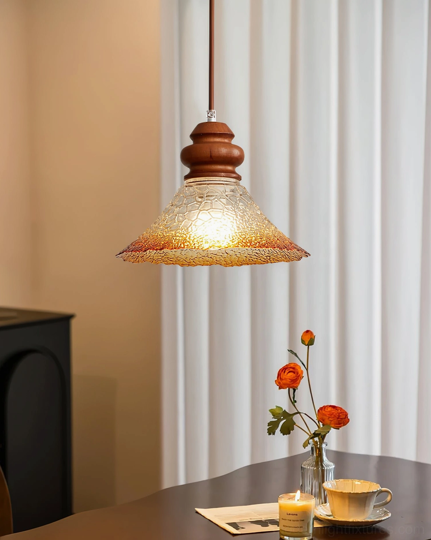 Brenna pendant light with gradient amber crackle glass shade hanging above dining table
