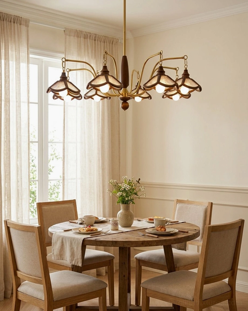 Multi-arm wood and brass chandelier overhead view in sunlit dining room with round wooden table, warm light distribution